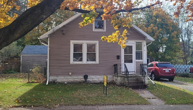 bungalow-style house with a front yard and fence