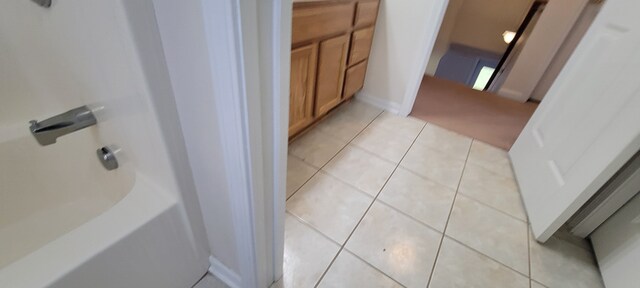 bathroom with baseboards, a bath, and tile patterned floors