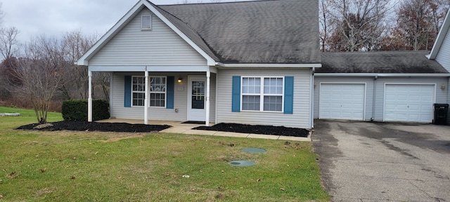 view of front of house with a garage, driveway, a shingled roof, covered porch, and a front yard