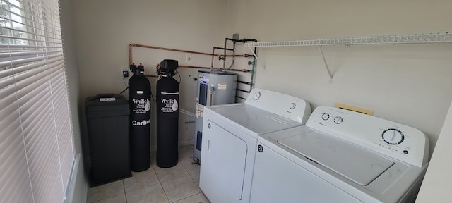 laundry area with laundry area, electric water heater, washer and clothes dryer, and light tile patterned floors