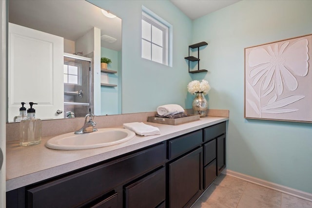 bathroom with a stall shower, tile patterned flooring, baseboards, and vanity