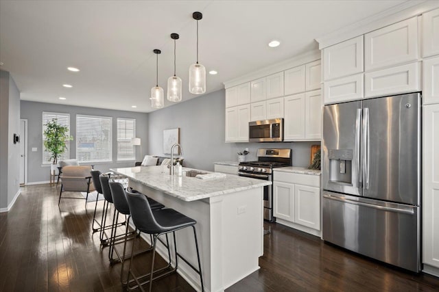 kitchen featuring appliances with stainless steel finishes, dark wood-type flooring, a sink, and white cabinetry