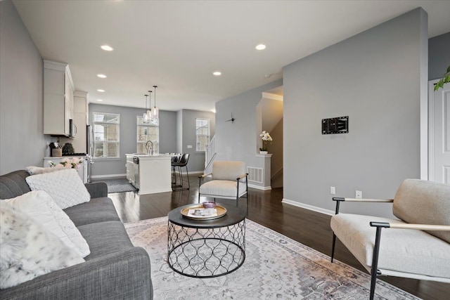 living room with baseboards, dark wood-type flooring, visible vents, and recessed lighting