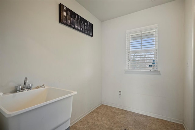 empty room with baseboards and a sink