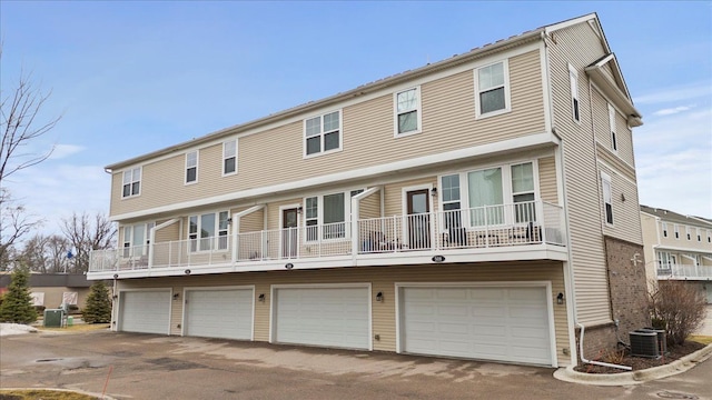 view of front facade with a garage, cooling unit, and driveway