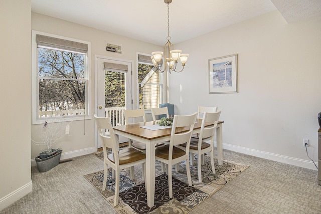 carpeted dining area with an inviting chandelier and baseboards