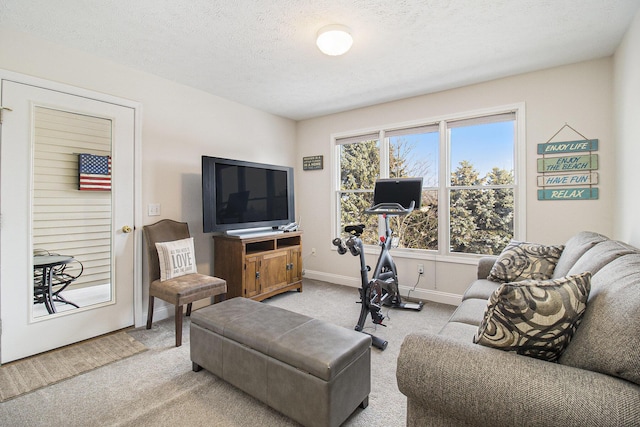 living room featuring light carpet, baseboards, and a textured ceiling