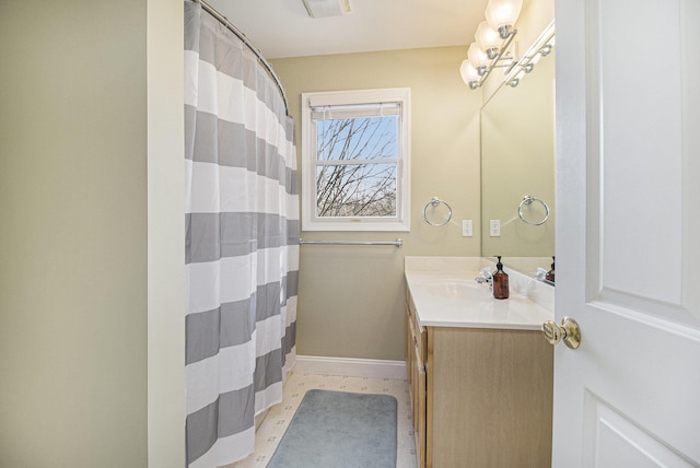 full bathroom with curtained shower, vanity, and baseboards