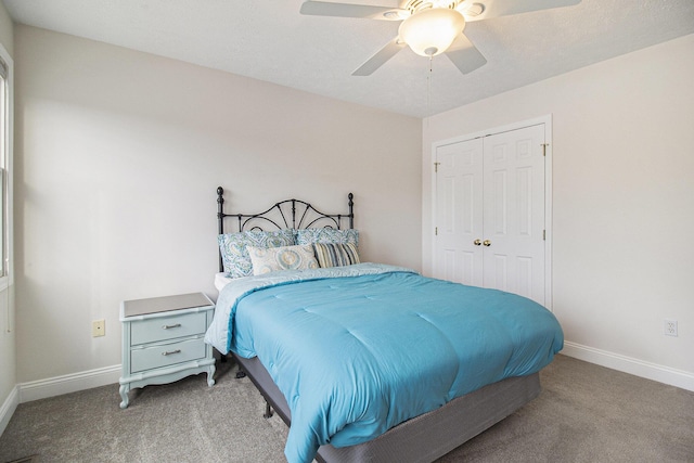 carpeted bedroom with ceiling fan, baseboards, and a closet