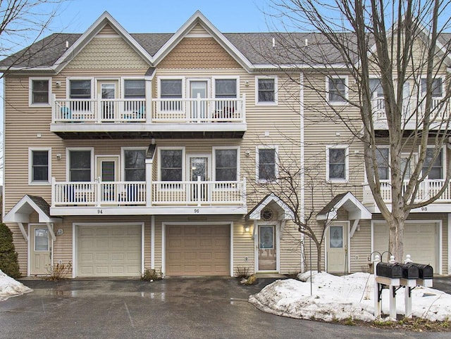 multi unit property featuring driveway and a garage