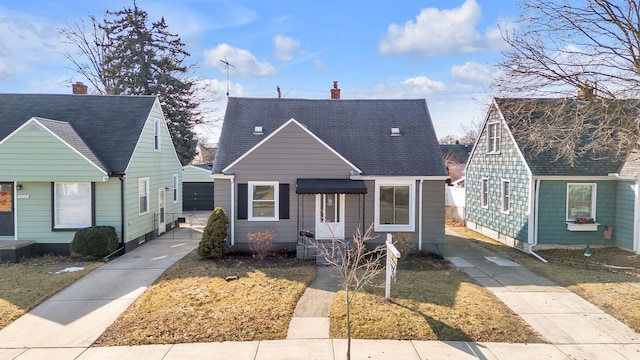 bungalow-style house with roof with shingles and a chimney