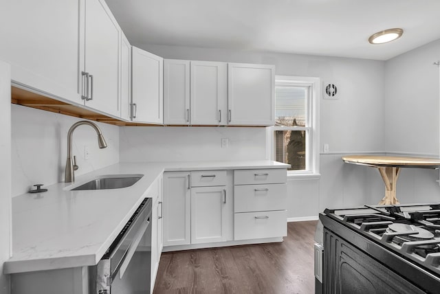 kitchen with stainless steel dishwasher, dark wood-type flooring, a sink, and white cabinetry