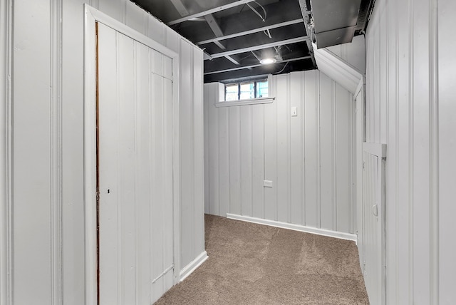 basement with carpet flooring and wooden walls