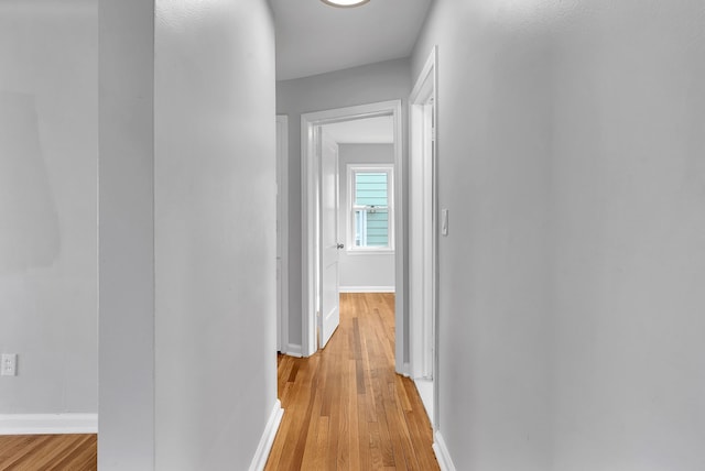 hallway with light wood-style floors and baseboards