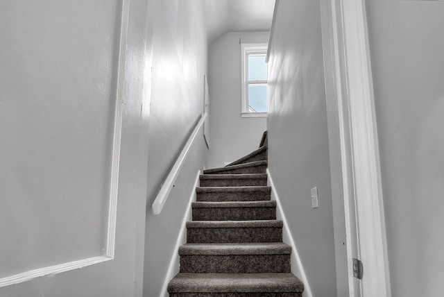 stairs featuring vaulted ceiling