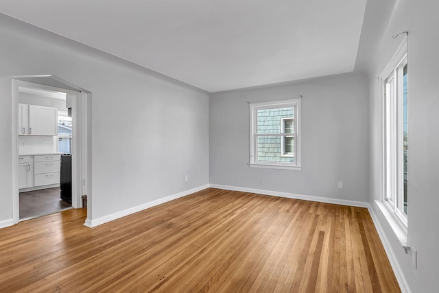 empty room featuring light wood-type flooring and baseboards