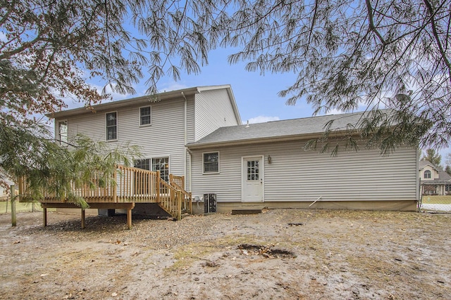 rear view of property with fence, a deck, and central air condition unit