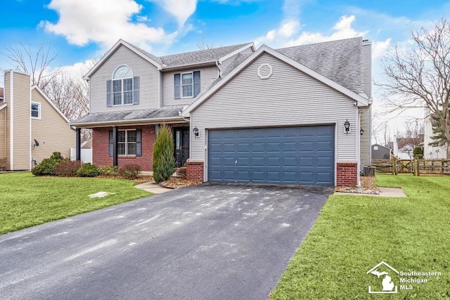 traditional-style home with brick siding, an attached garage, fence, driveway, and a front lawn