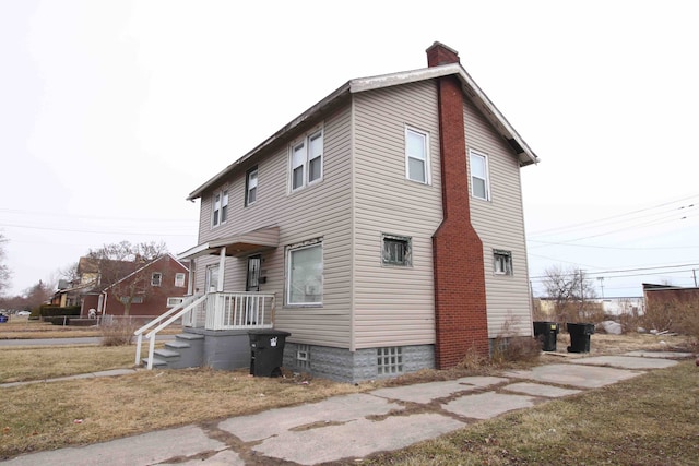 view of property exterior featuring a yard and a chimney