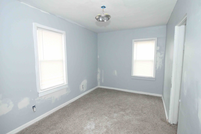 unfurnished room featuring carpet and baseboards