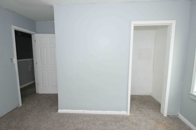 empty room featuring carpet floors and baseboards