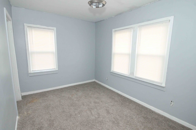 carpeted empty room with baseboards