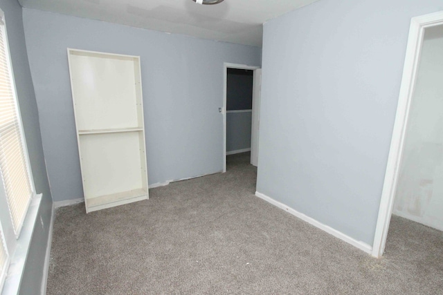 unfurnished bedroom with a closet, carpet flooring, and baseboards