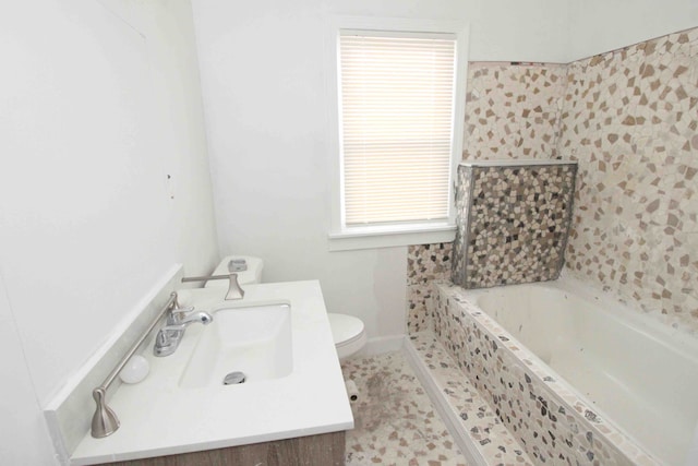 bathroom featuring tiled bath, toilet, vanity, baseboards, and tile patterned floors