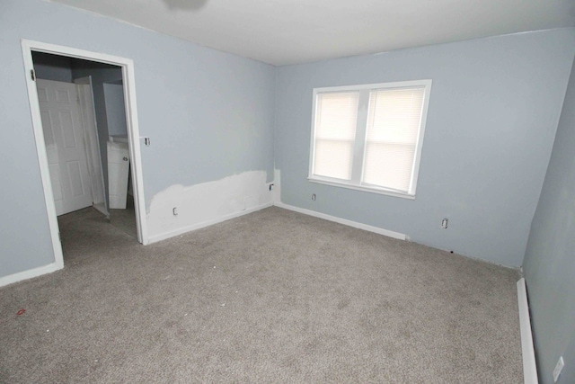 unfurnished room with carpet flooring and baseboards