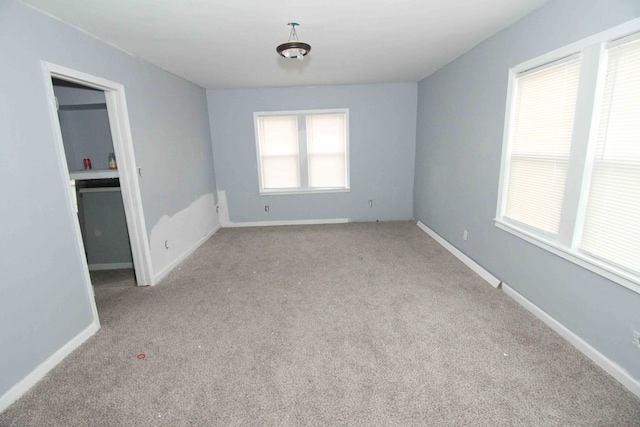 carpeted empty room with baseboards