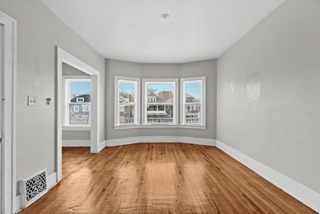 unfurnished room with visible vents, baseboards, and wood finished floors