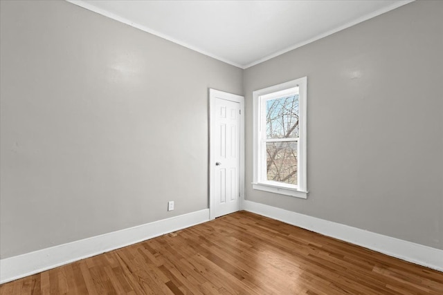 unfurnished room with baseboards, wood finished floors, and ornamental molding