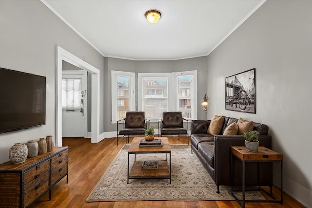 living room with ornamental molding, wood finished floors, and baseboards