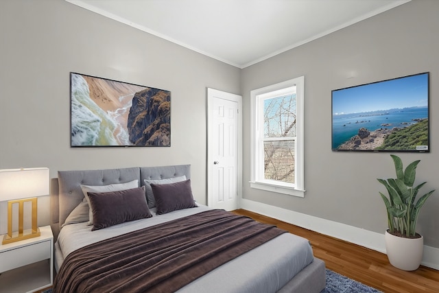 bedroom featuring ornamental molding, baseboards, and wood finished floors