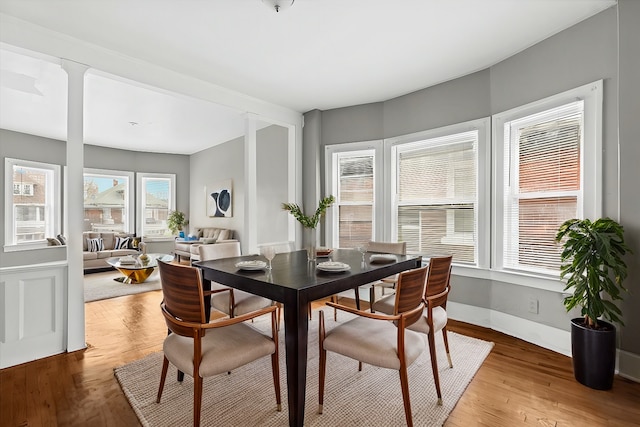 dining area with light wood-type flooring and baseboards