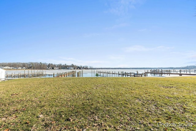 view of dock with a water view and a yard