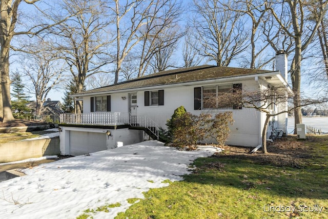 single story home featuring brick siding, a chimney, and an attached garage