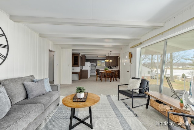 carpeted living room featuring beam ceiling