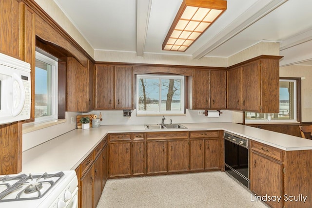 kitchen with light countertops, a sink, white appliances, beamed ceiling, and a peninsula