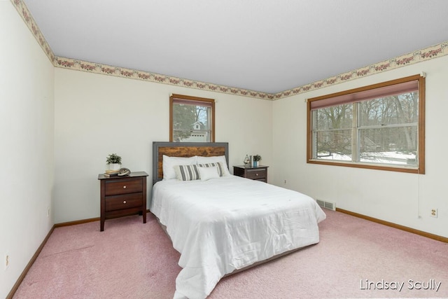 bedroom with multiple windows, visible vents, and light colored carpet