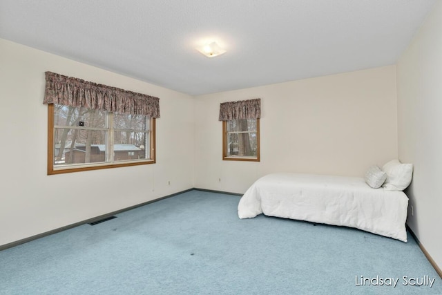 unfurnished bedroom with carpet, visible vents, and baseboards