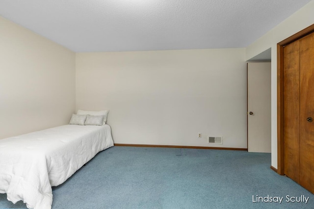 unfurnished bedroom with baseboards, carpet, visible vents, and a textured ceiling