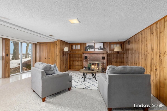 carpeted living area with a textured ceiling, a brick fireplace, and wooden walls