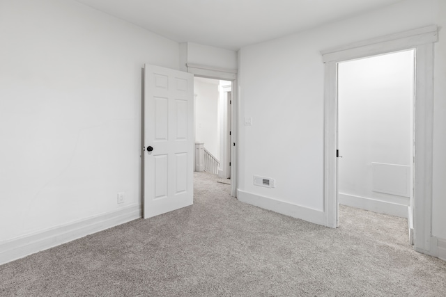 unfurnished bedroom with carpet floors, visible vents, and baseboards