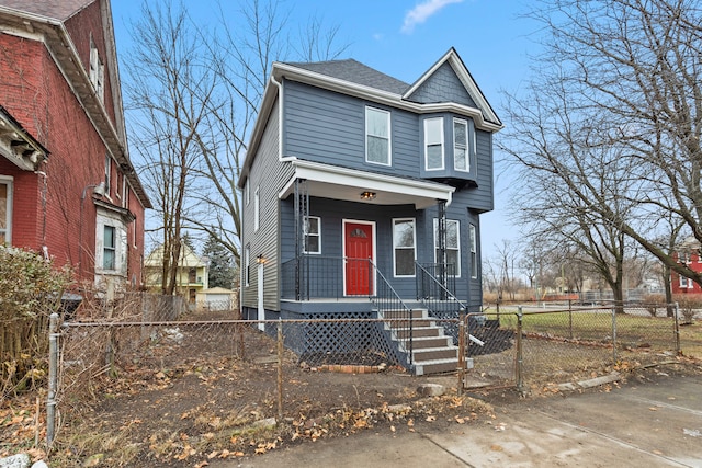 view of front of property with fence private yard, a gate, and roof with shingles