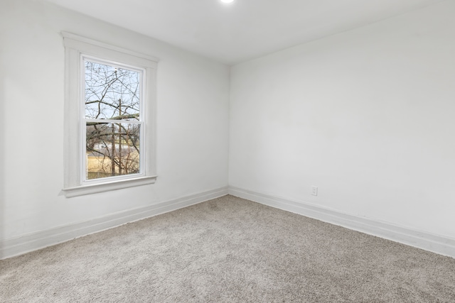 carpeted spare room with baseboards