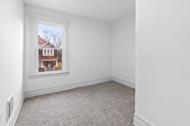 spare room featuring carpet and baseboards