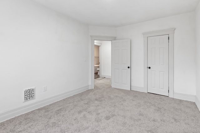 unfurnished bedroom with carpet, visible vents, and baseboards