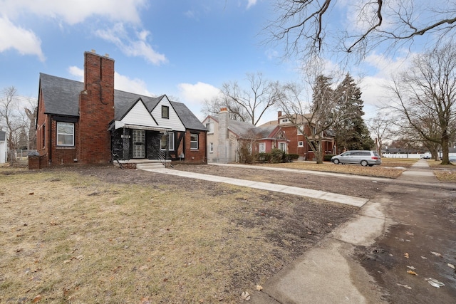 view of front of home featuring brick siding and a chimney