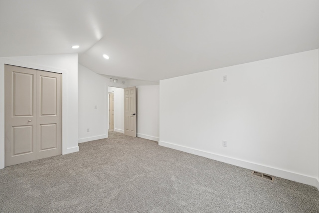 unfurnished bedroom featuring baseboards, visible vents, lofted ceiling, carpet floors, and recessed lighting